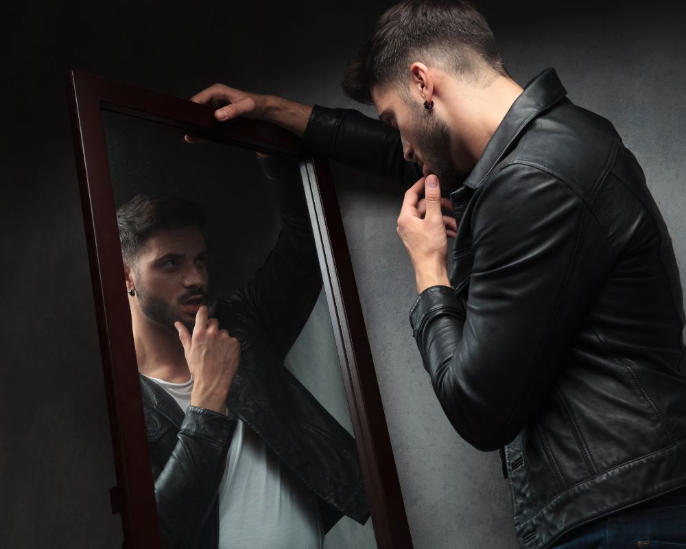 a narcissist man looking at the mirror obsessively