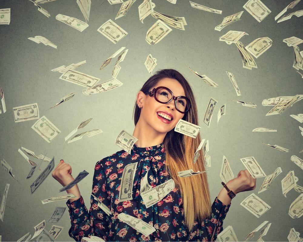 money flying in the air and woman is excited and smiling at her success