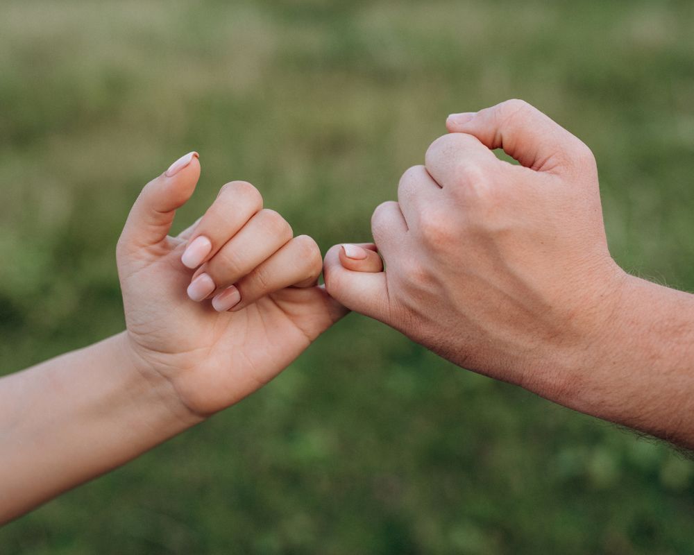 a couple affectionately entangling their fingers