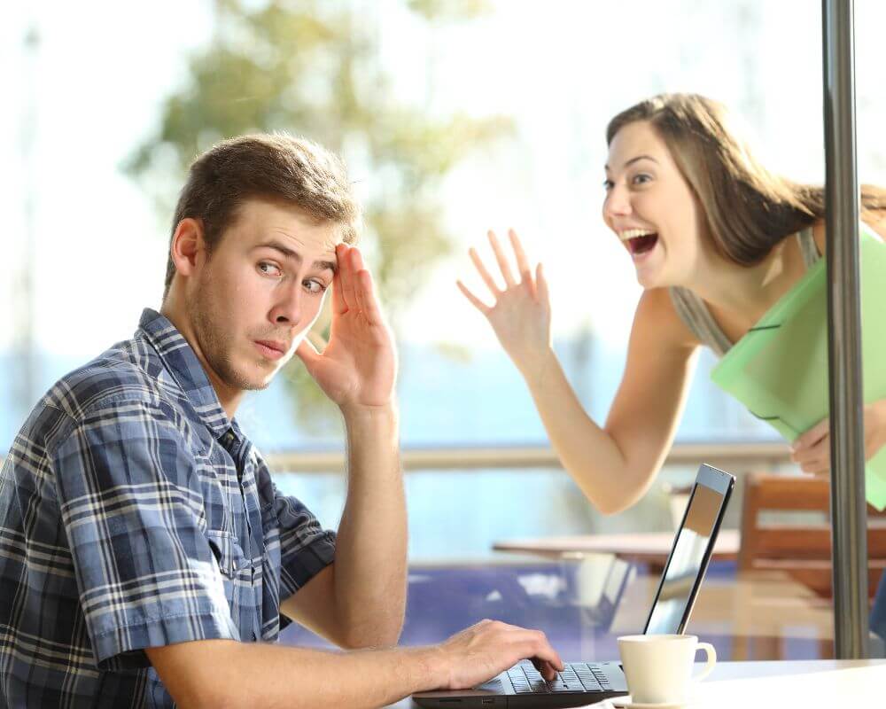 man avoiding eye contact while a woman waves from short distances