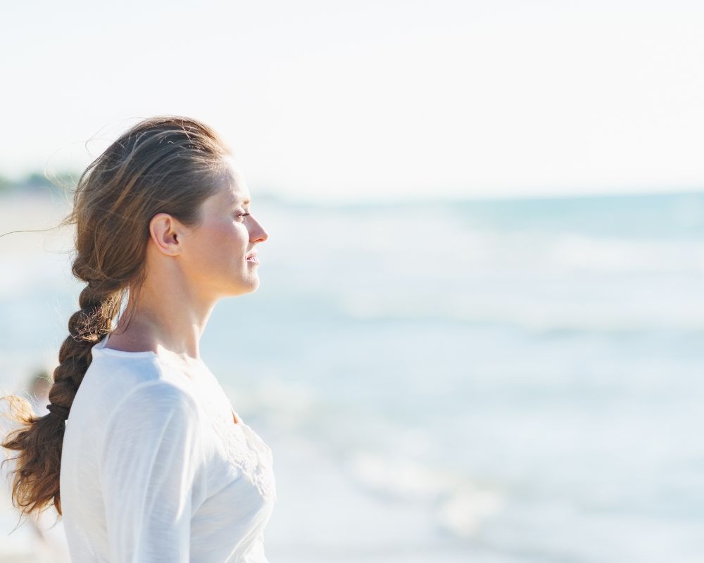  woman standing ashore and calmly watching ahead