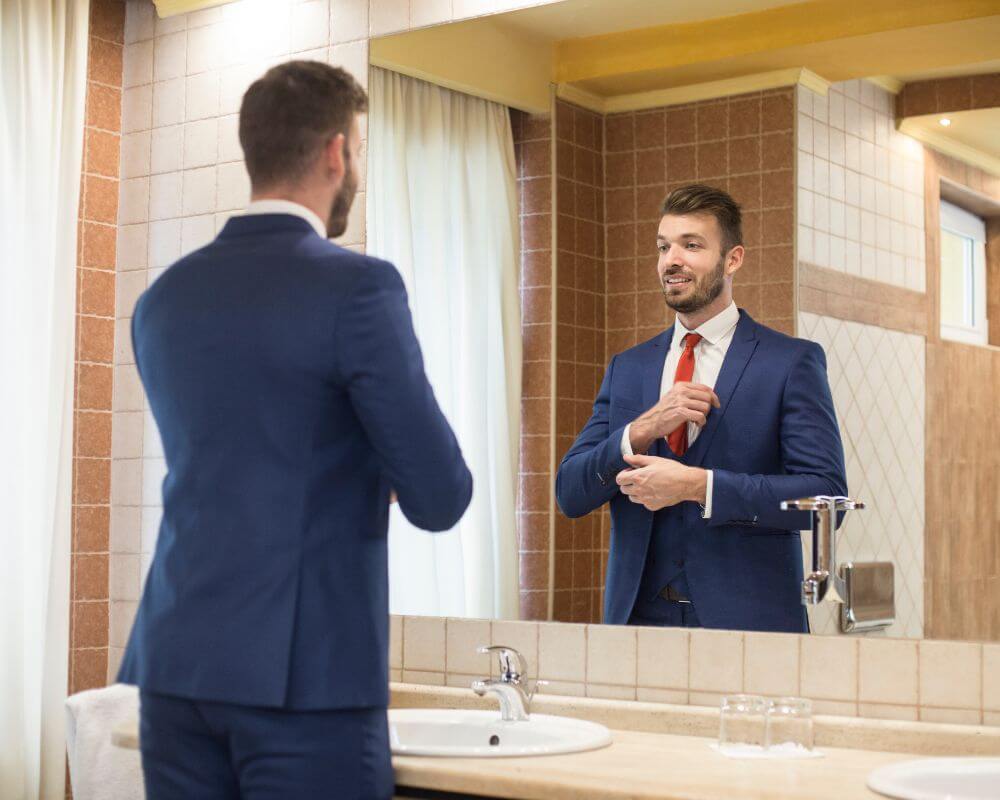 man getting ready and fixing his tie excitingly