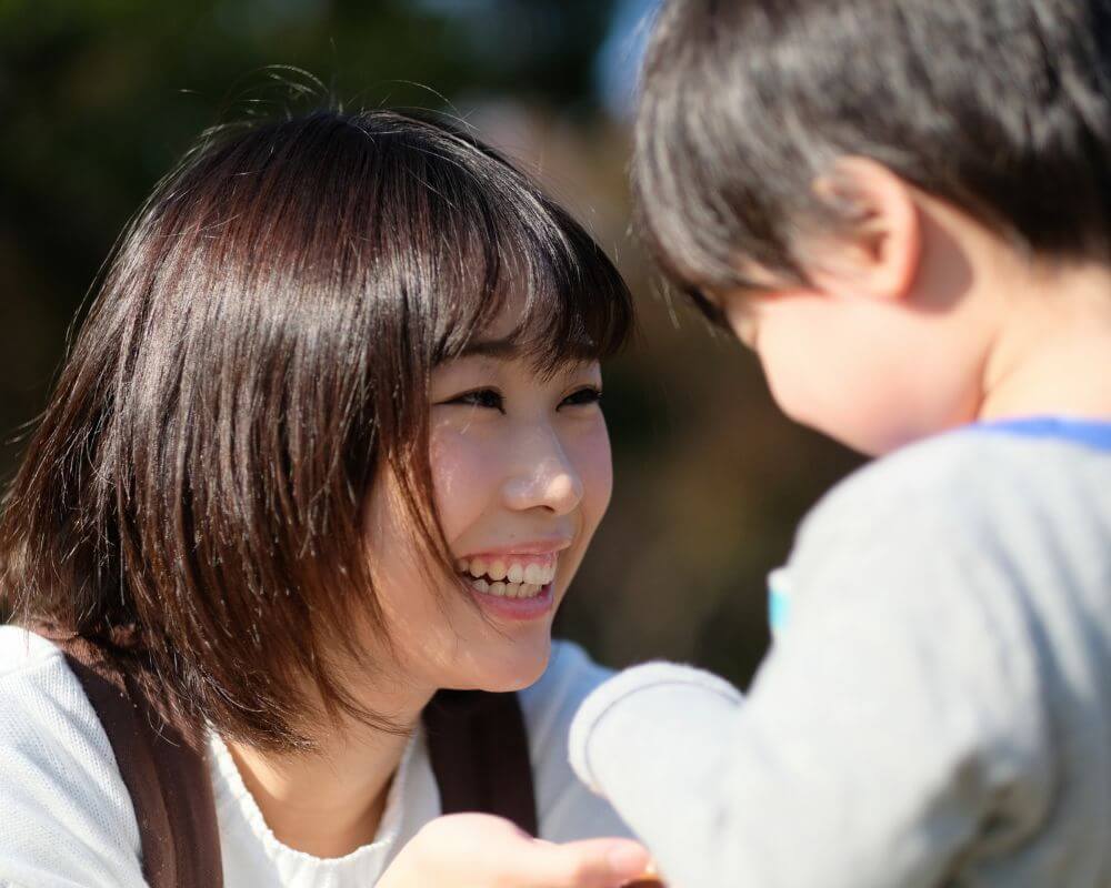 a woman talking to a child and both of them are laughing