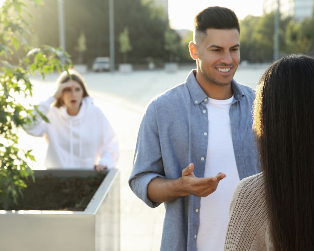 narcissist person talking to a woman while ex hides and watches