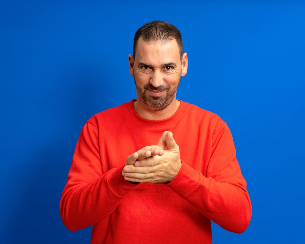 a man standing having the gesture of "pretending something"