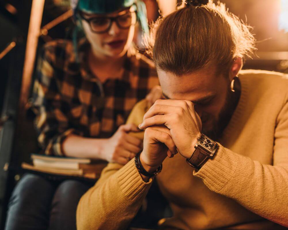 remorseful man sitting beside a woman