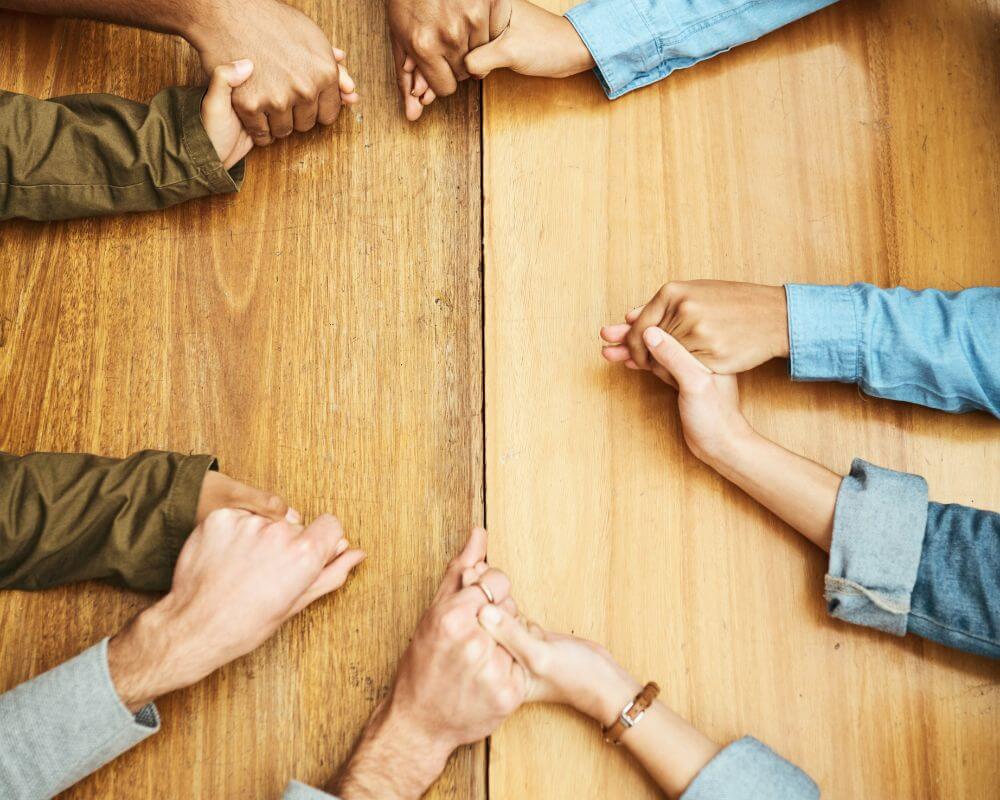 people holding each other's hands as a sign of support