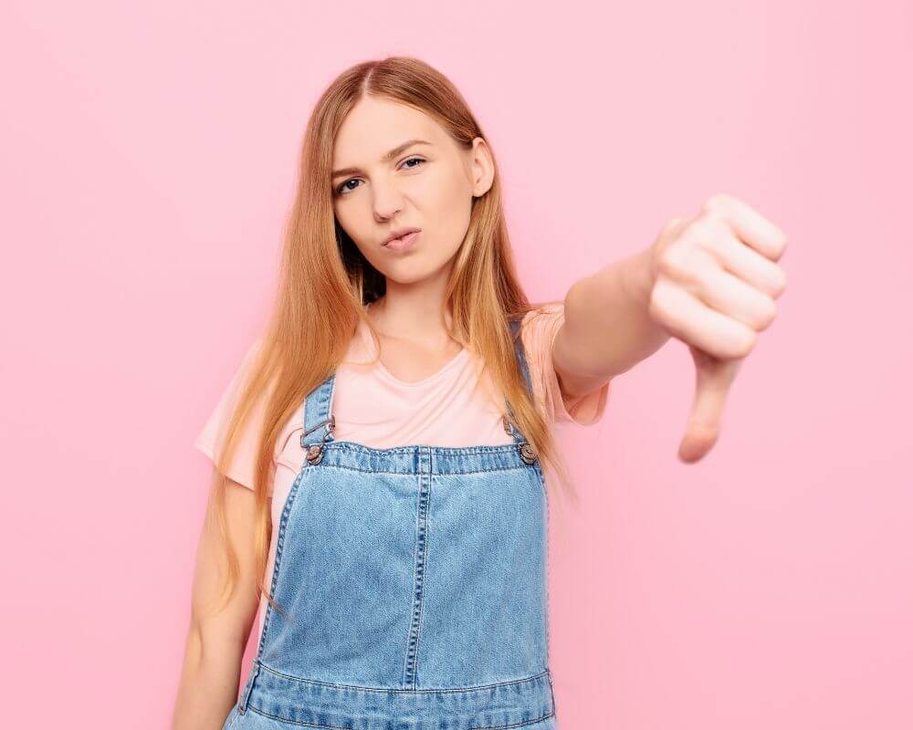 woman showing thumbs down with disgust